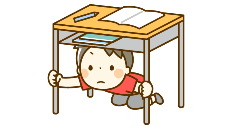 地震の時に机の下に隠れる男の子